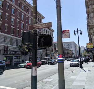 Mockup showing proposed street signage identifying the LEATHER & LGBTQ Cultural District, and wraparound leather flag designs on light poles.